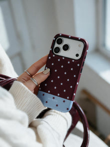 Burgundy Stars phone case in an everyday hand detail scene
